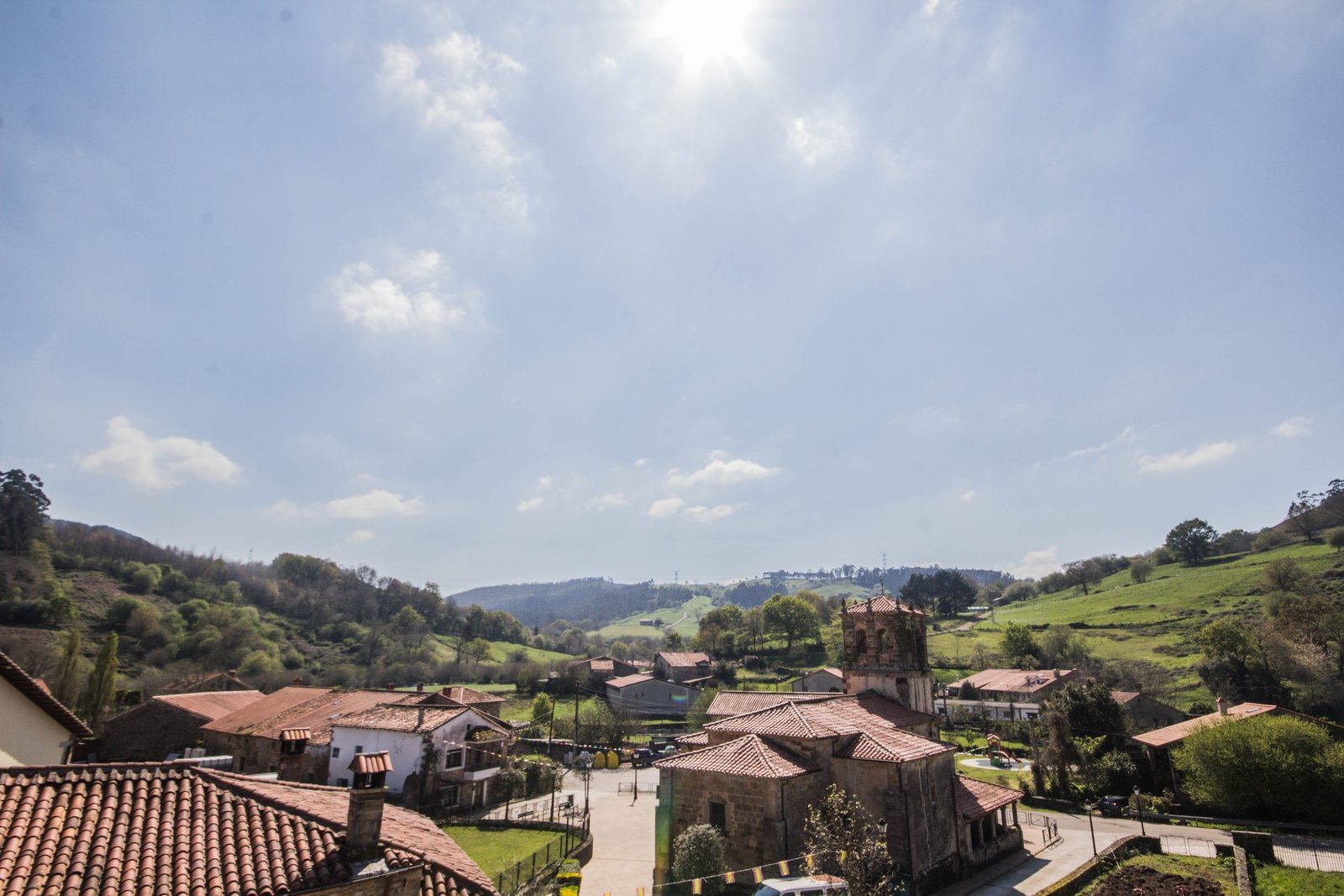 Vista aérea del pueblo de Llanos de Penagos con iglesia, tejados de teja y colinas verdes